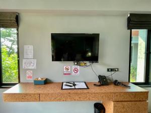 un comptoir avec un téléviseur sur un mur dans l'établissement ProudChan Boutique Resort, à Chanthaburi 6 autres photos
