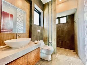 une salle de bain avec un lavabo et des toilettes dans l'établissement ProudChan Boutique Resort, à Chanthaburi