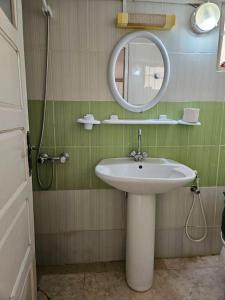 a bathroom with a sink and a mirror at Hadhri Appartement in Tozeur