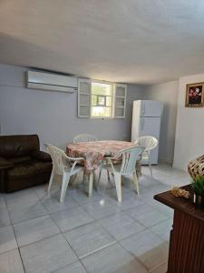 a living room with a table and chairs and a refrigerator at Hadhri Appartement in Tozeur