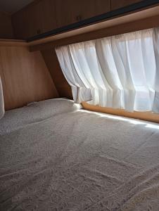 Posto letto in una piccola camera con finestra di Caravana Magic a Tindaya