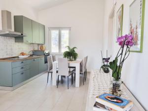 - une cuisine et une salle à manger avec une table et des chaises dans l'établissement La GreenHouse - Isola di Capo Rizzuto, à Isola di Capo Rizzuto
