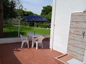 a table and chairs with an umbrella on a patio at Casa Scottodiuccio in Procida
