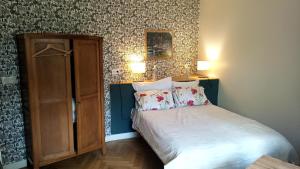 ル・トレポールにあるVoiles et Terrasses Le Treportのベッドルーム1室(ベッド1台付)、木製キャビネットが備わります。