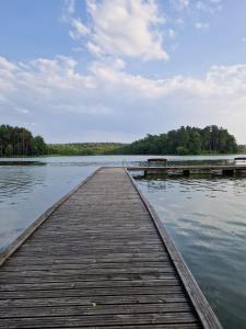 a wooden dock in the middle of a lake at Mieszkanie wakacyjne in Ruciane-Nida