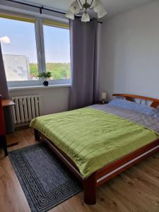 a bedroom with a bed and a large window at Mieszkanie wakacyjne in Ruciane-Nida