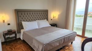 a bedroom with a large bed with a large window at Hotel Sakura in Torre del Greco