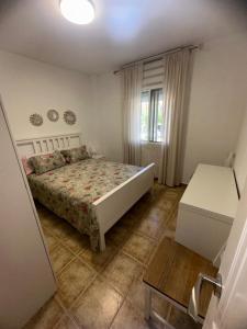 1 dormitorio con cama, ventana y mesa en Apartamento Patricia en Fuengirola