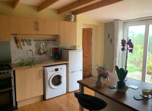 a kitchen with a washer and dryer in it at The Granary Country Retreat in Lampeter