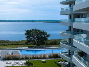 a view of a building with a swimming pool and a lake at Beachmee Condo Rogowo in Rogowo