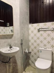 a bathroom with a toilet and a sink at 3 Retro-Antique Inspired Interconnected Family Rooms at Country Lodge - Eco Valley Retreat 豐之谷 in Tawau