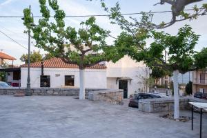 a building with two trees in a parking lot at Memories Gytheio in Gythio