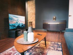 Una sala de estar con una mesa y un televisor. en Silti, atjaunoti dzīvokļi tuvu centram - 1st floor, en Riga