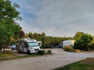 een witte vrachtwagen geparkeerd op een parkeerplaats met tenten bij Campingrosengarten in Cserszegtomaj