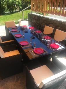 uma mesa longa com pratos vermelhos e copos em Superbe chalet 10 personnes 5 chambres Les Houches em Les Houches