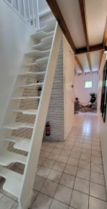 una escalera en una sala de estar con estanterías blancas en Le Boisclary, en Boissy-Saint-Léger