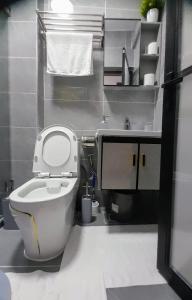 a bathroom with a white toilet and a sink at Smarthomes Apartment in Nairobi