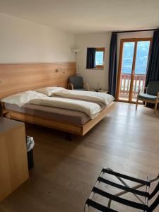 a bedroom with a large bed and a chair at Hotel Restaurant Kulm in Triesenberg