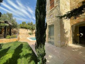 a tree in front of a building with a yard at Horizon1 in Amman