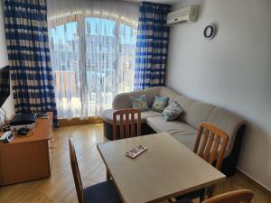 een woonkamer met een tafel en een bank bij Golden Dreams Apartment in Sunny Beach