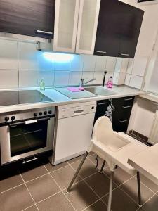 a kitchen with a stove and a sink and a chair at Moderne ruhige Wohnung Bochum angebunden in Bochum