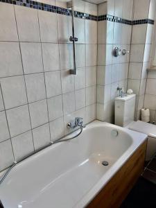 a white bathroom with a tub and a toilet at Moderne ruhige Wohnung Bochum angebunden in Bochum