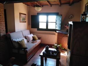 - un salon avec un canapé et une fenêtre dans l'établissement Casas rurales Caño Chico y La Fuente, à Villanueva del Conde