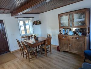 a dining room with a wooden table and chairs at Casa Buenos Aires in Ribadeo