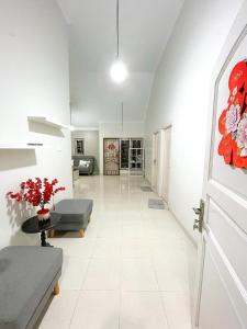 een woonkamer met witte muren en een witte tegelvloer bij Palm beach Guest House 12 in Nagoya