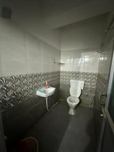 y baño con aseo y lavamanos. en Pearl villa homestay, en Jorhāt