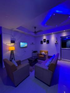 una sala de estar púrpura con sofás y TV en Pearl villa homestay, en Jorhāt