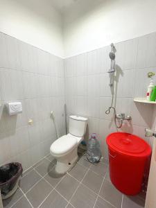 een badkamer met een toilet en een rode vuilnisbak bij Palm beach Guest House 12 in Nagoya