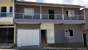 Casa con garaje blanco y balcón en Casa para temporada Pico da Bandeira, en Caparaó Velho