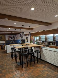 a restaurant with tables and bar stools at Brauereigasthof Bären in Titisee-Neustadt