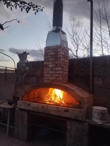 Un horno de ladrillo con fuego. en GuestHouse ED&ER near airport, en Geghanist