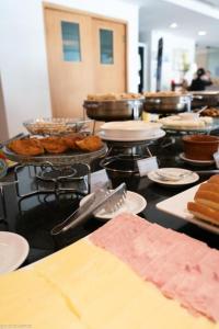 a buffet line with pastries and other food items at Flat moderno com piscina e academia in Itaboraí