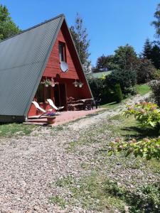 a red barn with a porch and a patio at Domki nad potokiem w Baligrodzie in Baligród +1 photo