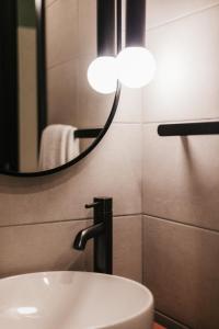 uma casa de banho com um lavatório e um espelho em Eleven by Warren Collection em Sliema