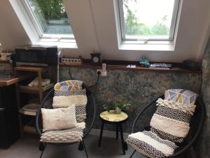 a room with two chairs and a table and two windows at The Granary Country Retreat in Lampeter