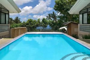 a swimming pool in the backyard of a house with blue water at Shrivasta Cottages in Itum