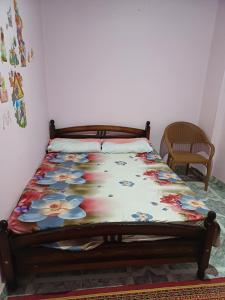 een bed in een kamer met een sprei met bloemen erop bij Room in Al Bitash Main Street, Alex west in Alexandrië