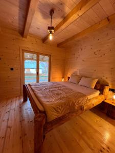 a bedroom with a bed in a log cabin at Brvnara La Forêt in Žabljak