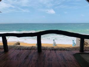 a view of the beach from a wooden deck at Bara Beach Home in Galle