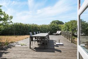 a wooden deck with a table and chairs on it at Feriehus med havudsigt in Hasle
