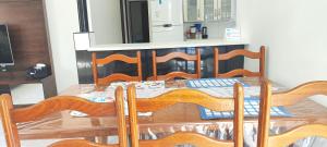 - une table à manger avec une table et des chaises en bois dans l'établissement Casa térrea com piscina a 250 metros da praia, à Itanhaém