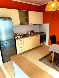a kitchen with white cabinets and a stainless steel refrigerator at Apartments Casa Toni Dubrovnik in Dubrovnik