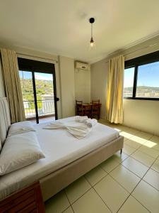 1 dormitorio con 1 cama grande y balcón en Bora Rooms, en Himare