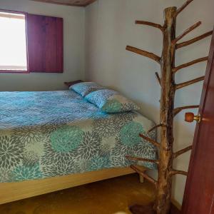 ein Schlafzimmer mit einem Bett und einem Baum in der Unterkunft Finca La Macarena by Welttisch in Génova