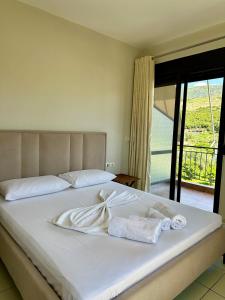 1 dormitorio con 1 cama con toallas en Bora Rooms, en Himare