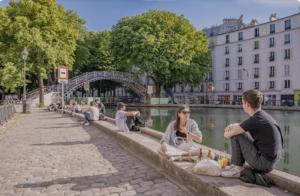 a group of people sitting next to a body of water at Chez vous - Marguerite et Emile in Paris
